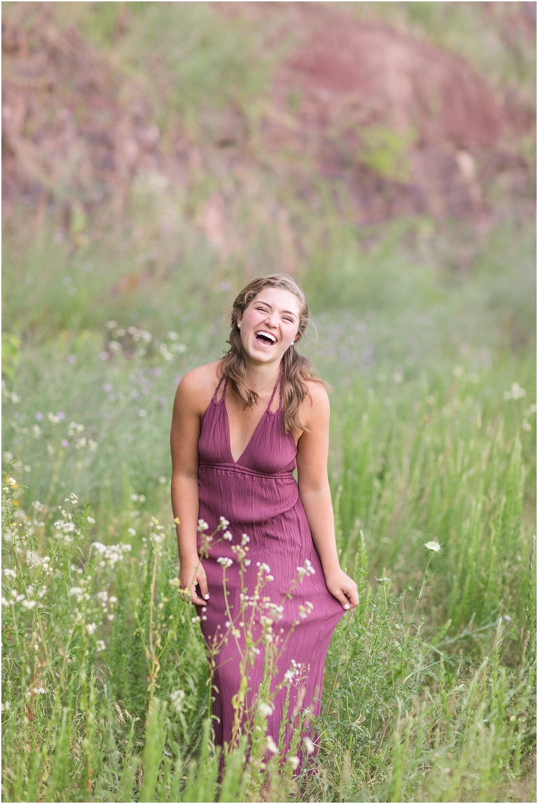 Senior photos of a girl in a purple dress in a flower field