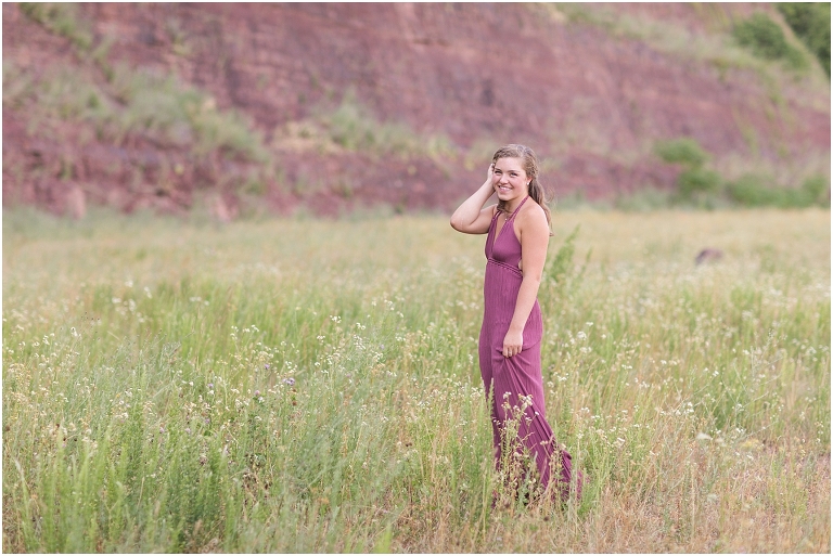 Senior photos of a girl in a purple dress in a flower field
