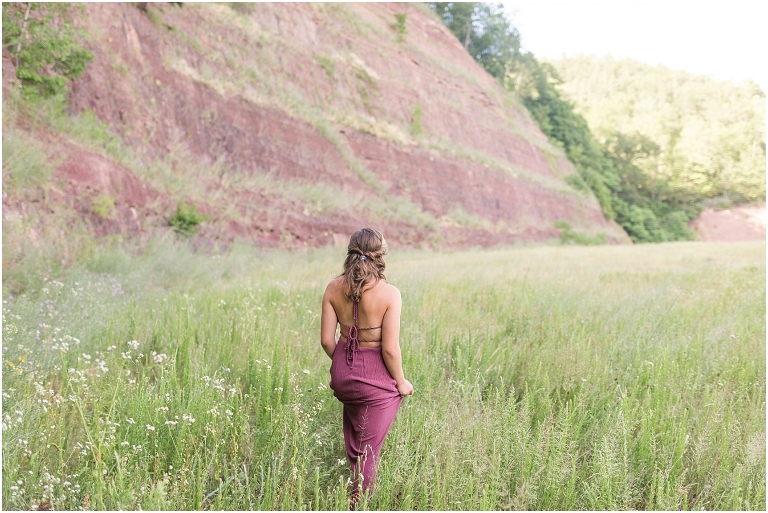 Senior photos of a girl in a purple dress in a flower field