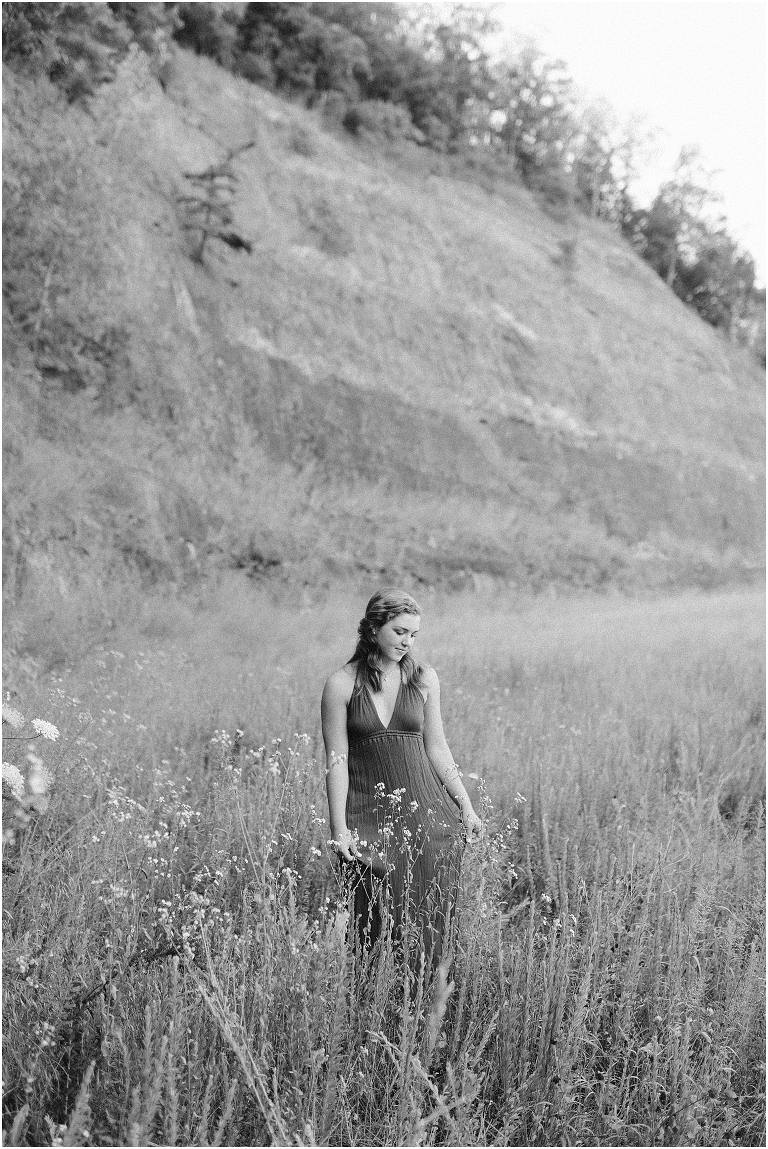 Senior photos of a girl in a purple dress in a flower field