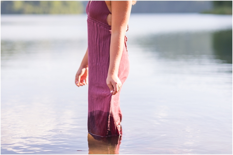 Switzer Lake senior photos of a girl in a purple dress in a lake with a mountain background taken by a Virginia portrait photographer