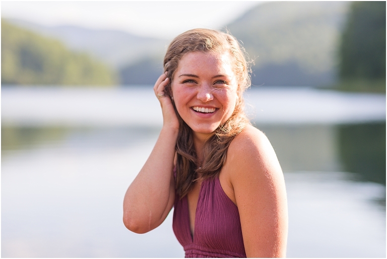 Switzer Lake senior photos of a girl in a purple dress in a lake with a mountain background taken by a Virginia portrait photographer