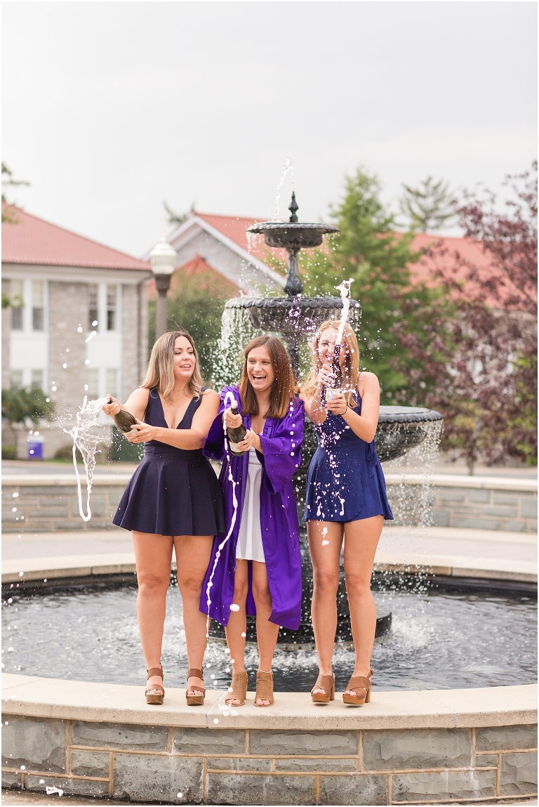 JMU senior and two friends pop champagne bottles in celebration at the fountain.