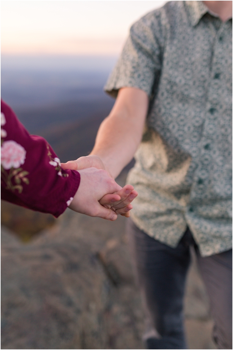 Couple holding hands at engagement session.