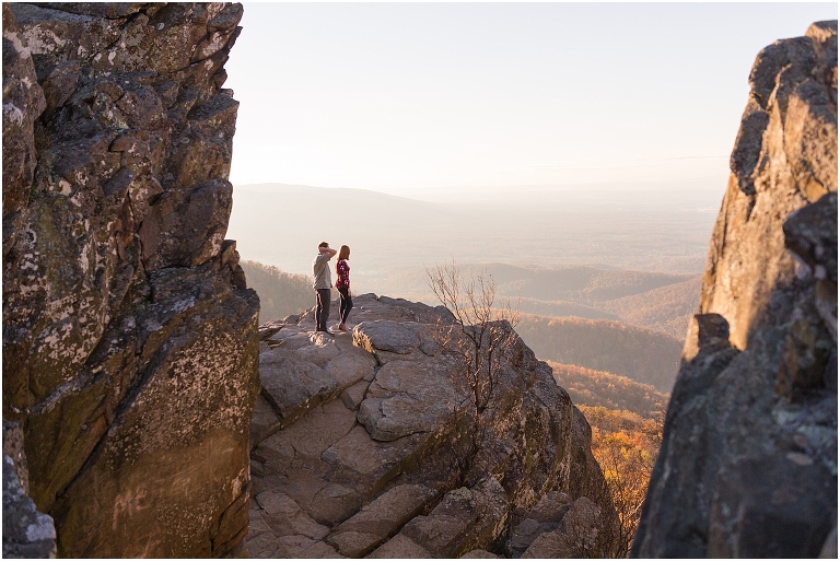 Couple at engagement session at Humpback Rocks during sunset, surrounded by fall colors and blue sky.