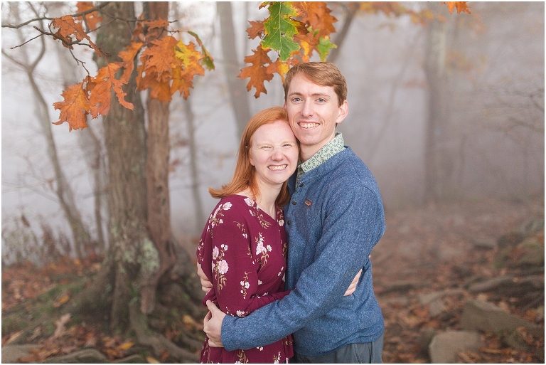 Couple during engagement session with fog surrounding them.