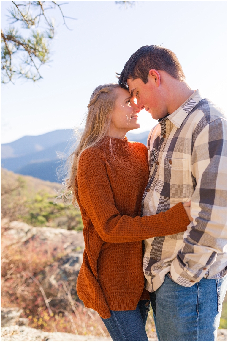 Blue Ridge engagement session with fall foliage and blue skies surrounding them.  Blue Ridge Parkway in Virginia. 