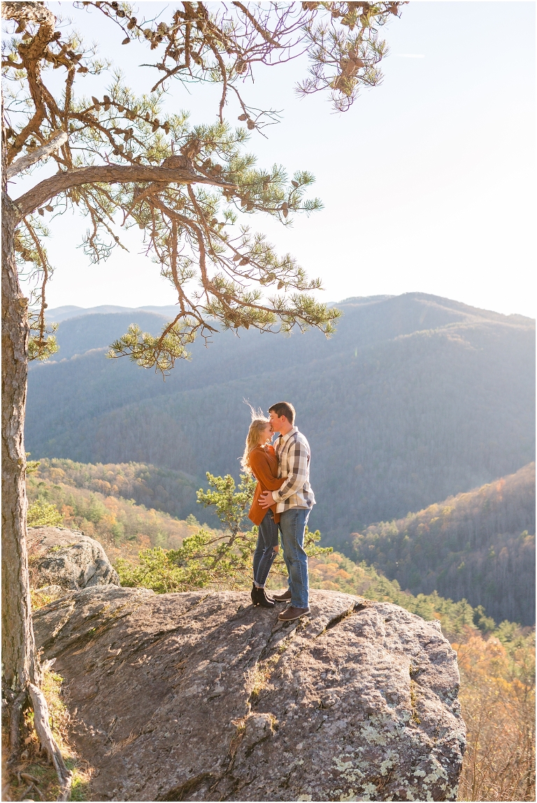 Blue Ridge engagement session with fall foliage and blue skies surrounding them.  Blue Ridge Parkway in Virginia. 