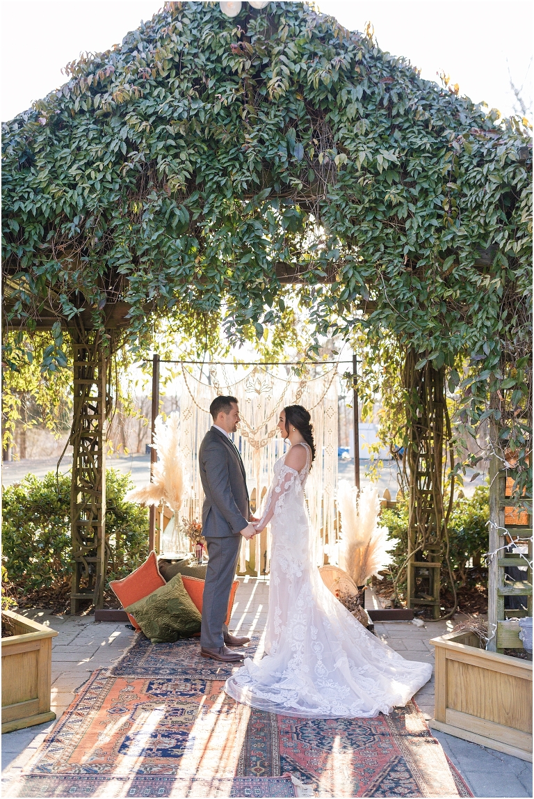 Boho intimate wedding elopement inspiration under the ivy at a reflecting pool in Virginia with macrame wedding arbor, pampas grass, and a boho wedding setup