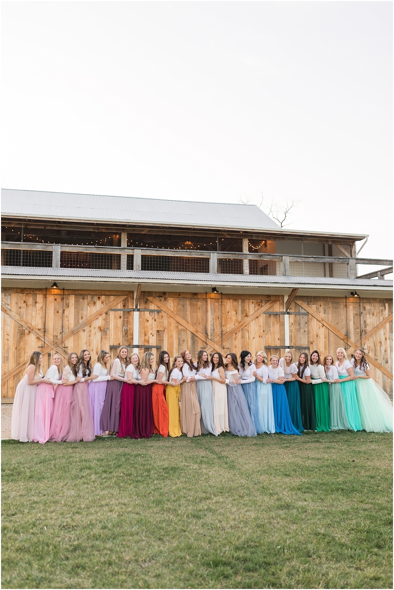 High school senior portraits with rainbow long skirts at a brown and white barn with a sunset mountain view in the Shenandoah Valley Virginia The Senior Giveback Project