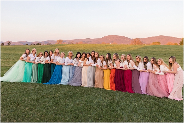 High school senior portraits with rainbow long skirts at a brown and white barn with a sunset mountain view in the Shenandoah Valley Virginia The Senior Giveback Project