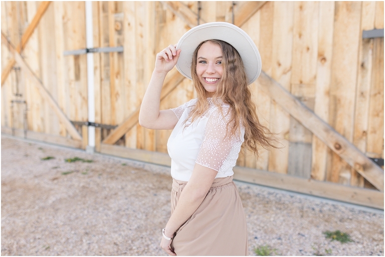 High school senior portraits with tan long skirt at a brown and white barn with a sunset mountain view in the Shenandoah Valley Virginia The Senior Giveback Project