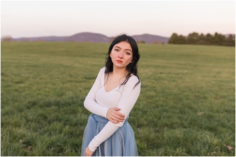 High school senior portraits with blue long skirt at a brown and white barn with a sunset mountain view in the Shenandoah Valley Virginia The Senior Giveback Project
