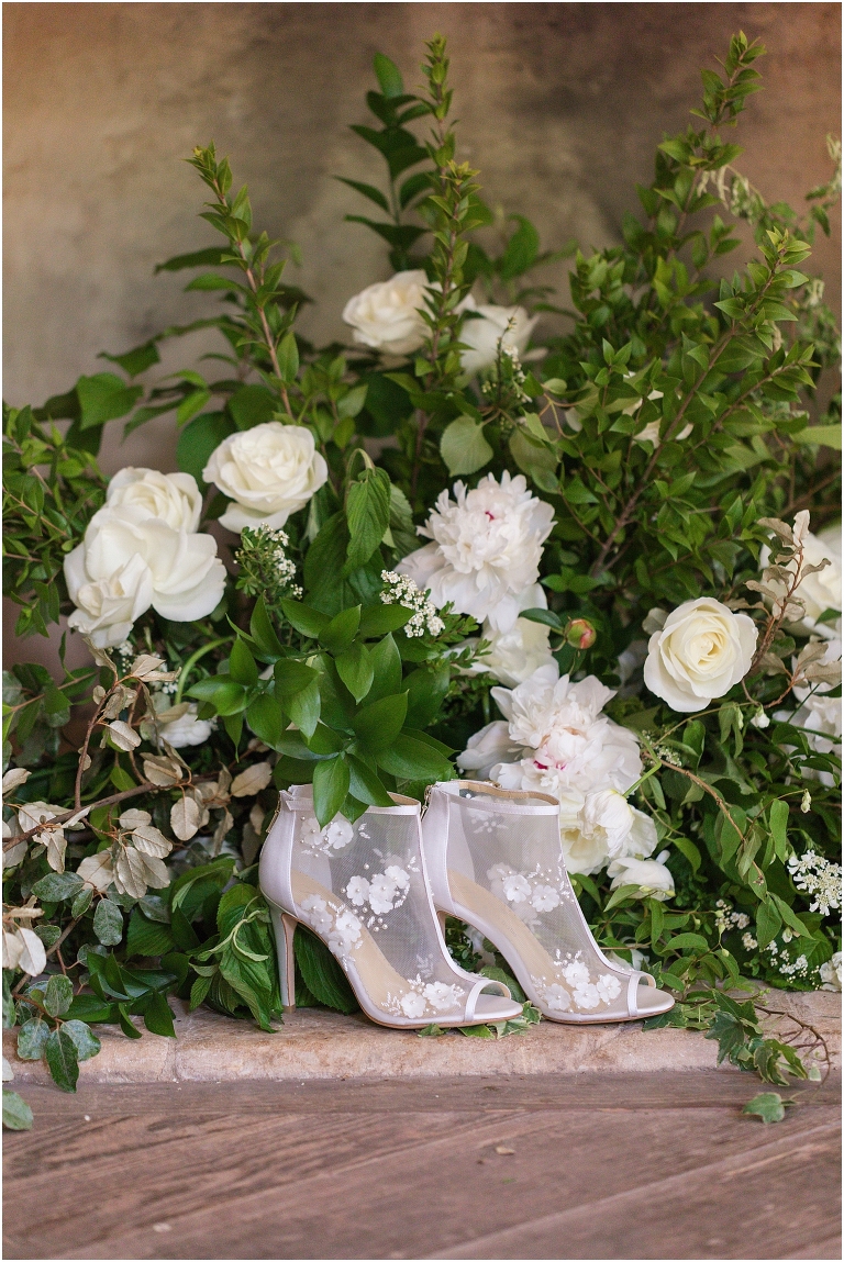Romantic and classic garden manor wedding inspiration white boot heels in a green and white floral display