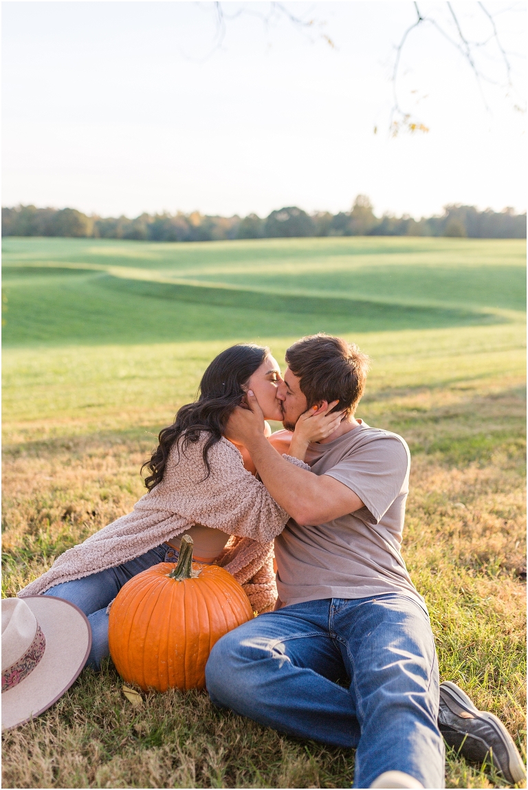 Country couples session pumpkin carving in an open field during golden hour