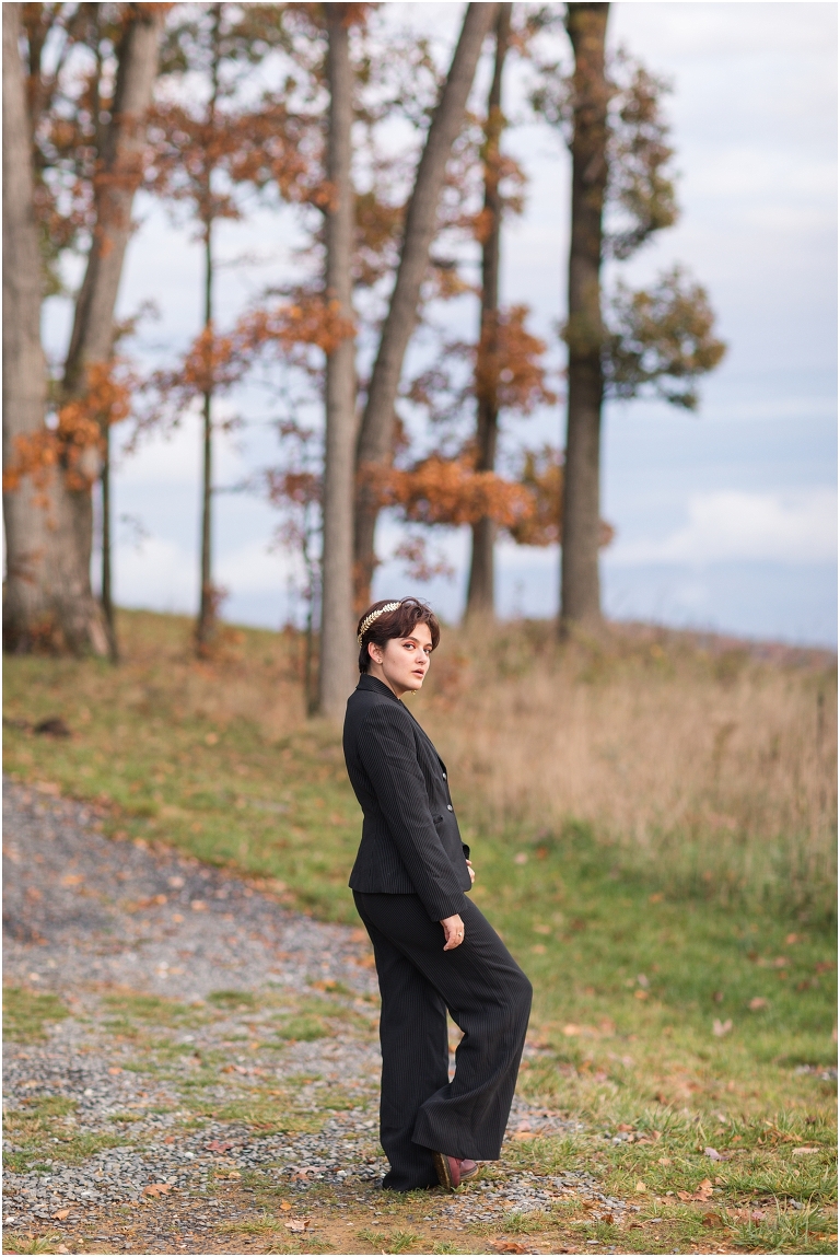 Ares Greek Mythology inspired portrait session all black suit golden crown at the top of a hill with a sunset mountain view