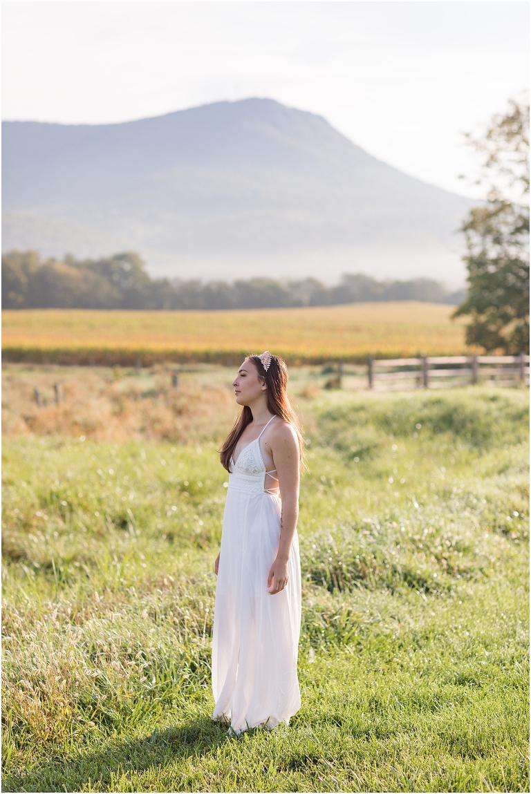 Demeter Greek Mythology goddess of agriculture inspired portrait session white dress golden crown in an open field next to corn with a sunrise mountain view