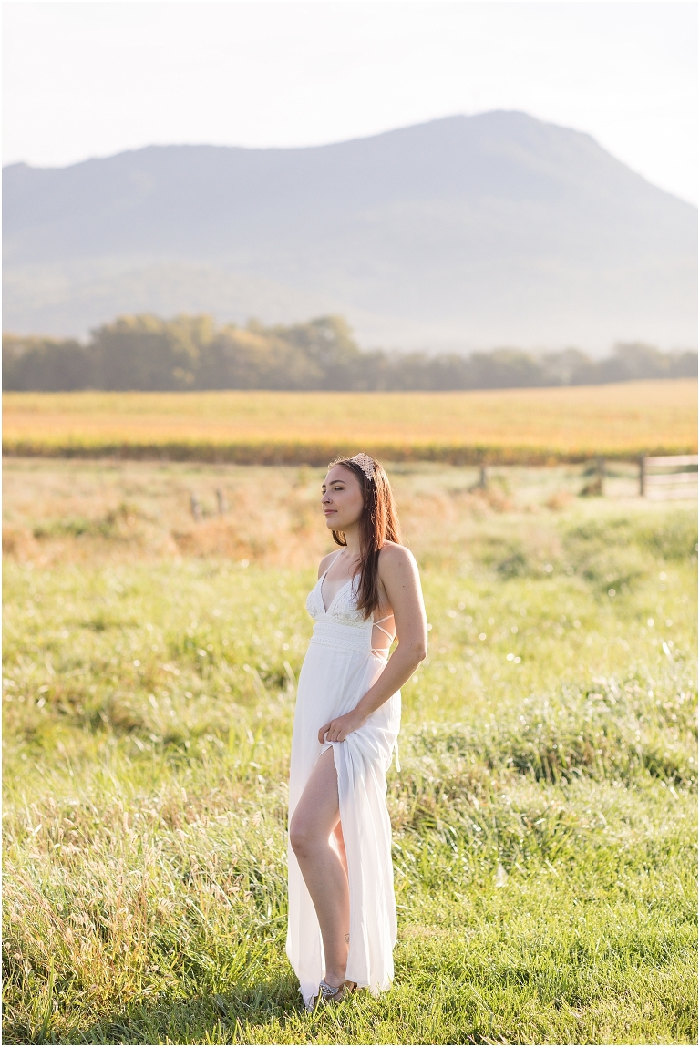 Demeter Greek Mythology goddess of agriculture inspired portrait session white dress golden crown in an open field next to corn with a sunrise mountain view