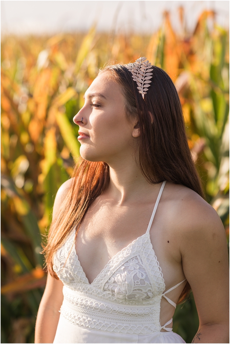 Demeter Greek Mythology goddess of agriculture inspired portrait session white dress golden crown in an open field next to corn with a sunrise mountain view