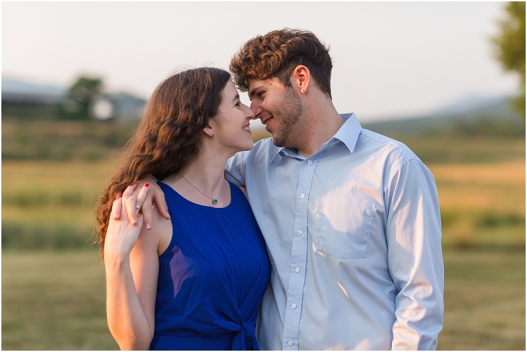 Summer couples portraits in an open field during golden hour with a mountain view