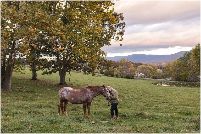 Autumn fall foliage senior horse portraits with a rust and white horse in an open field with a sunset mountain backdrop, Virginia senior graduation portrait photographer
