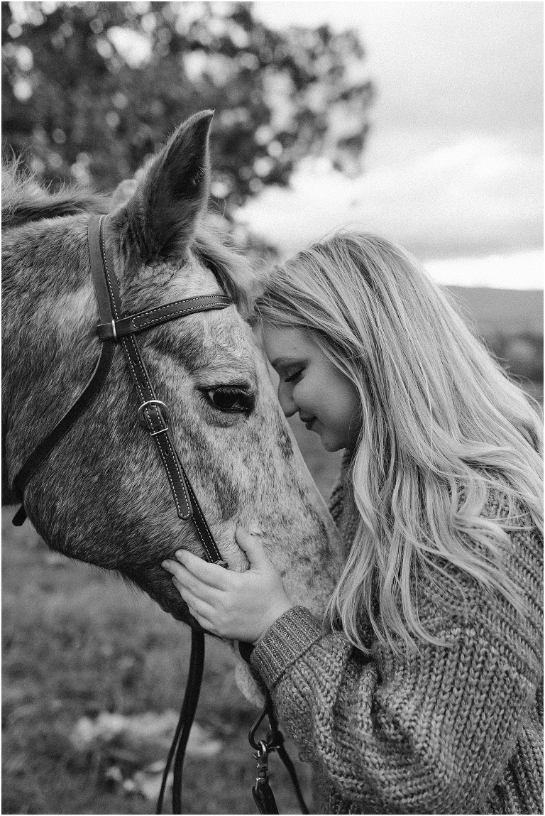 Black and white autumn fall foliage senior horse portraits with a rust and white horse in an open field with a sunset mountain backdrop, Virginia senior graduation portrait photographer