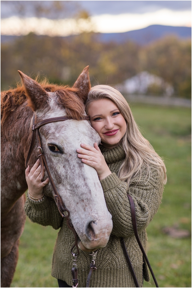 Autumn fall foliage senior horse portraits with a rust and white horse in an open field with a sunset mountain backdrop, Virginia senior graduation portrait photographer