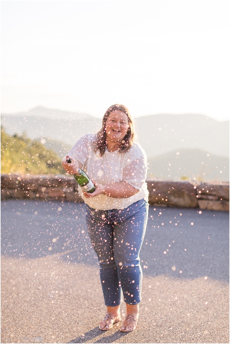 Autumn fall foliage senior portraits at a sunset mountain overlook on Skyline Drive in Shenandoah National Park popping champagne, Virginia senior graduation portrait photographer