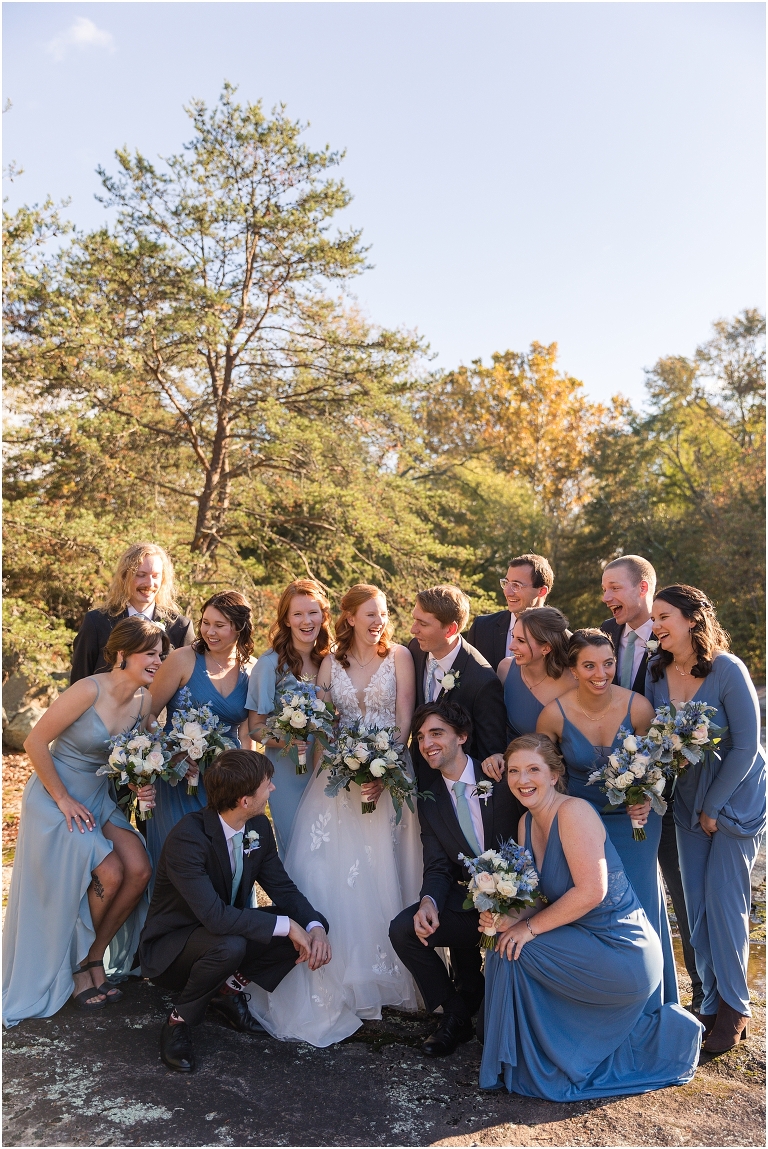 Emma & Dan's The Mill at Fine Creek Richmond autumn wedding with a riverside first look, ceremony in the garden surrounded by fall foliage, and portraits in the fairy light lit abandoned mill at dusk. Blue wedding party dresses and suits photo