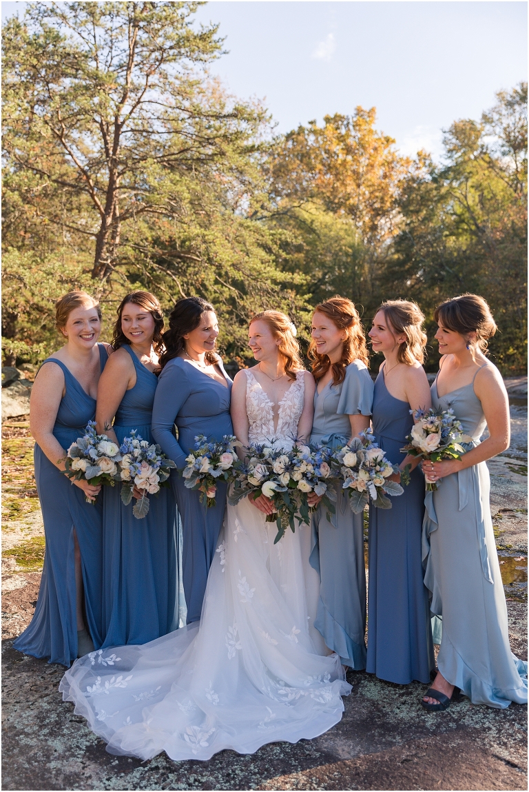 Emma & Dan's The Mill at Fine Creek Richmond autumn wedding with a riverside first look, ceremony in the garden surrounded by fall foliage, and portraits in the fairy light lit abandoned mill at dusk. Blue bridesmaid dresses photo