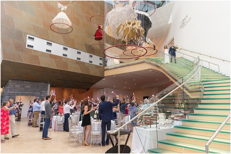 Savanna & Colin's Roanoke wedding with portraits under the magnolia trees at Hotel Roanoke and a reception and newlywed portraits at the Taubman Museum of Art. Wedding party exit photo with the newlyweds on a tandem bike