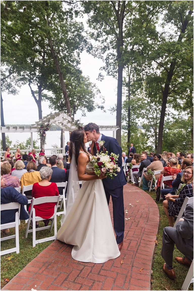 Allie & Cam's autumn riverside Richmond wedding at Celebrations at the Reservoir with a first dance under the lights, forest newlywed portraits, a dessert table, and a signature drink named after their dog.