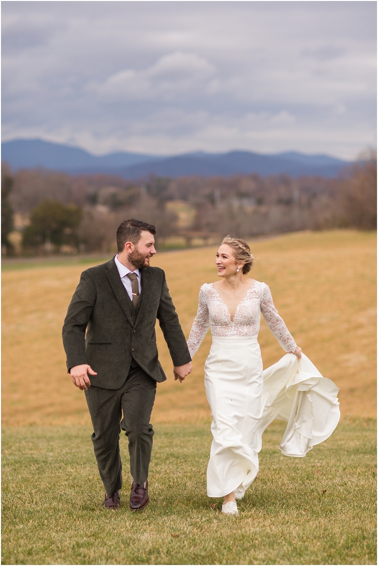 Kristin & Casey's green corduroy winter white barn wedding at Renback Barn with a custom wedding name sign, mountain view wedding portraits, all black wedding party clothes, wedding jean jacket, and sparkler exit.
