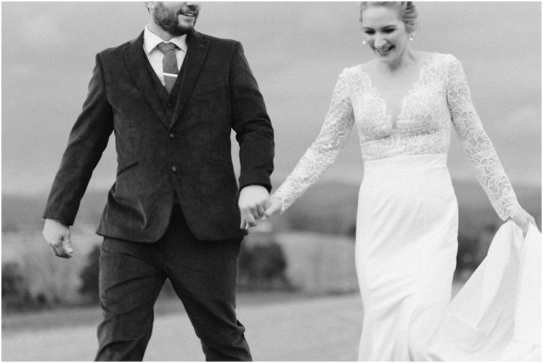 Kristin & Casey's green corduroy winter white barn wedding at Renback Barn with a custom wedding name sign, mountain view wedding portraits, all black wedding party clothes, wedding jean jacket, and sparkler exit.