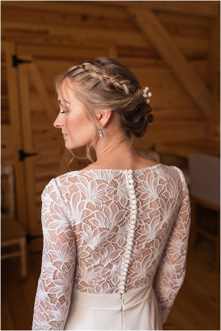 Kristin & Casey's green corduroy winter white barn wedding at Renback Barn with a custom wedding name sign, mountain view wedding portraits, all black wedding party clothes, wedding jean jacket, and sparkler exit.