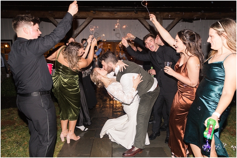 Kristin & Casey's green corduroy winter white barn wedding at Renback Barn with a custom wedding name sign, mountain view wedding portraits, all black wedding party clothes, wedding jean jacket, and sparkler exit.