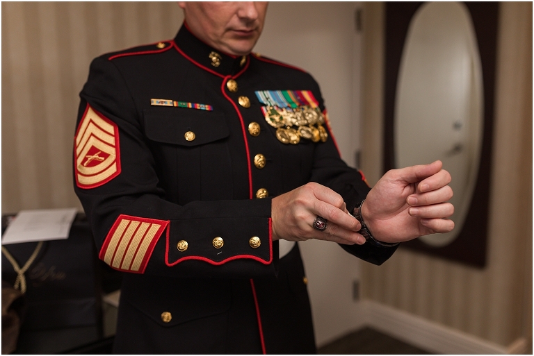 A groom getting dressed in his hotel room before his Virginia elopement