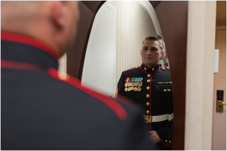 A groom getting dressed in his hotel room before his Virginia elopement