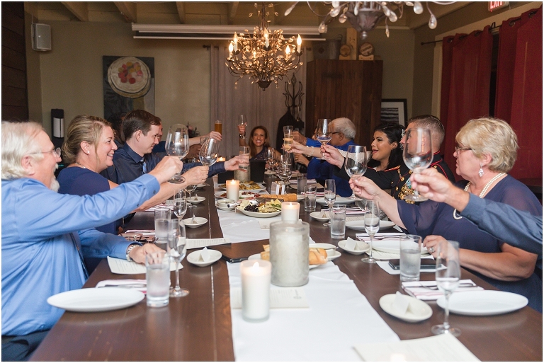 The guests at the restaurant reception cheering for the newlyweds after their elopement